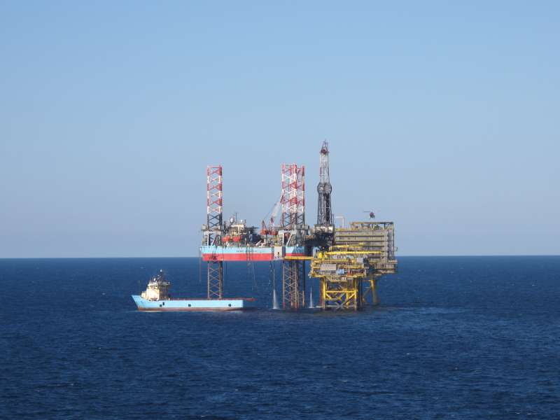 Offshore supportschip op zee bij schemering met satellietkoepels aan dek