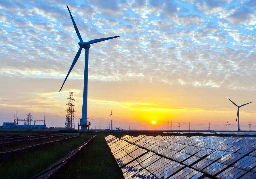 Windpark en zonnepanelen met hoogspanningsstation bij zonsondergang